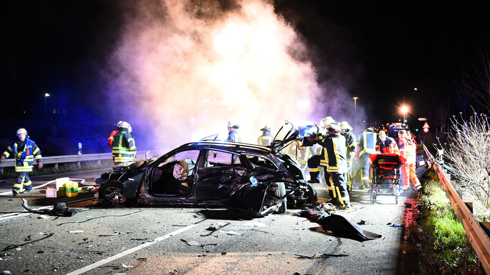 Einsatzkräfte von Polizei, Feuerwehr und Rettungsdiensten stehen bei der Unfallstelle: Vermutlich fuhr der Unglückswagen zu schnell. Einsatzkräfte von Polizei, Feuerwehr und Rettungsdiensten stehen bei der Unfallstelle: Vermutlich fuhr der Unglückswagen zu schnell.