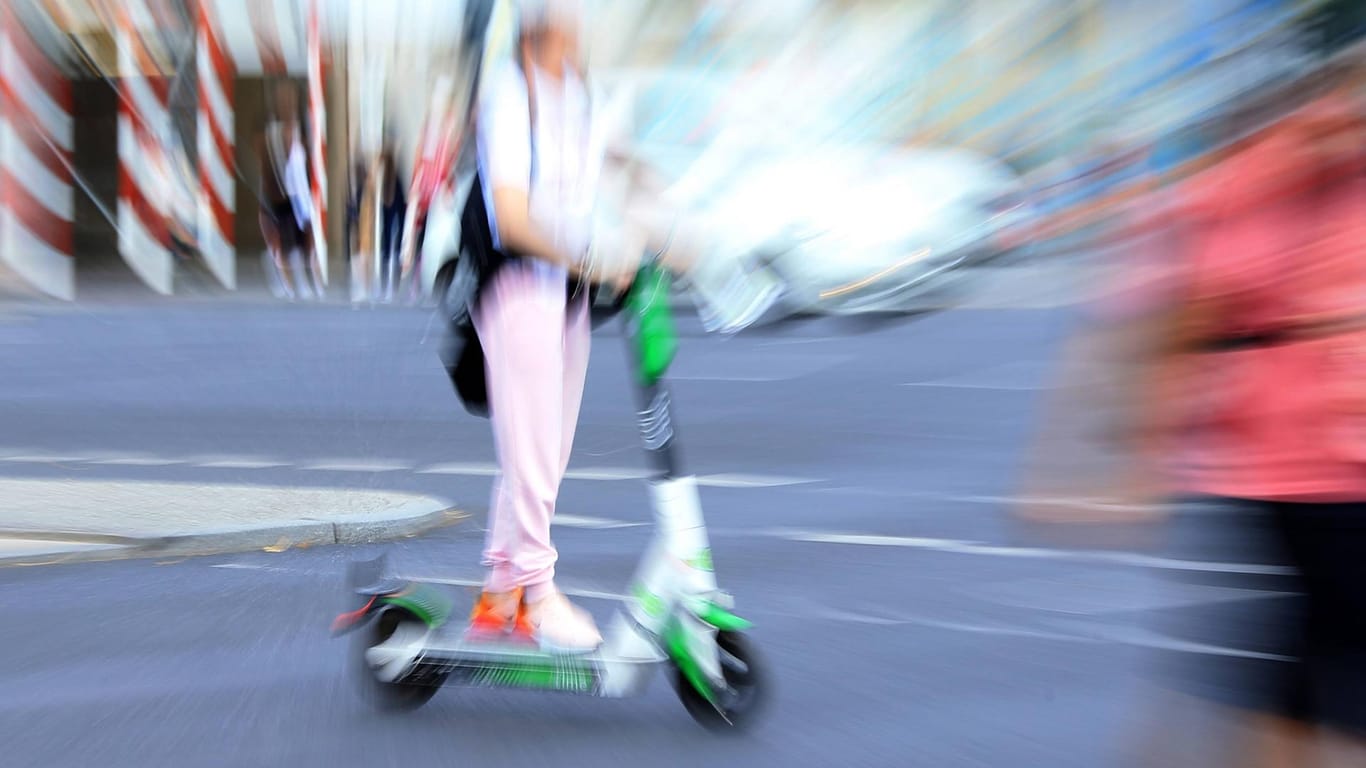 Ein E-Scooter-Fahrer fährt schnell zwischen Fußgängern (Symbolbild): Ein 33-jähriger Wolfsburger wurde betrunken auf einem E-Roller von der Polizei erwischt.