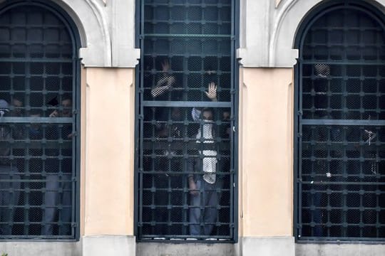Rebellierende Menschen hinter den Fenstern des San-Vittore-Gefängnisses.