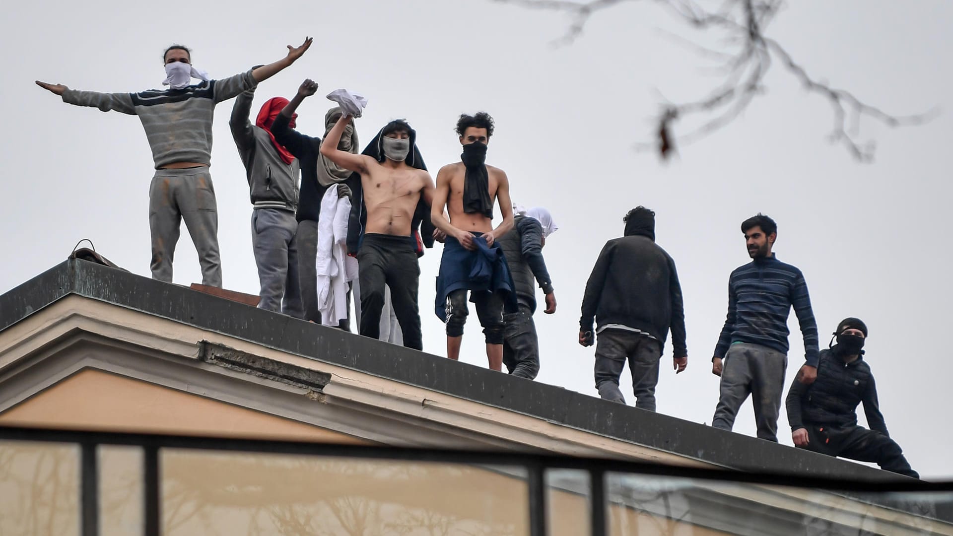 Teils vermummte Insassen stehen auf dem Dach des San-Vittore-Gefängnisses in Mailand.