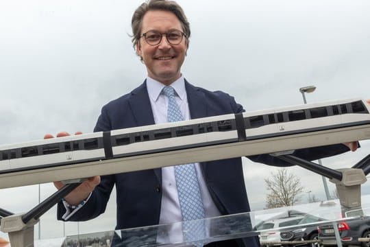 Andreas Scheuer (CSU) steht nach einer Pressekonferenz hinter einem Modell einer Magnetschwebebahn.