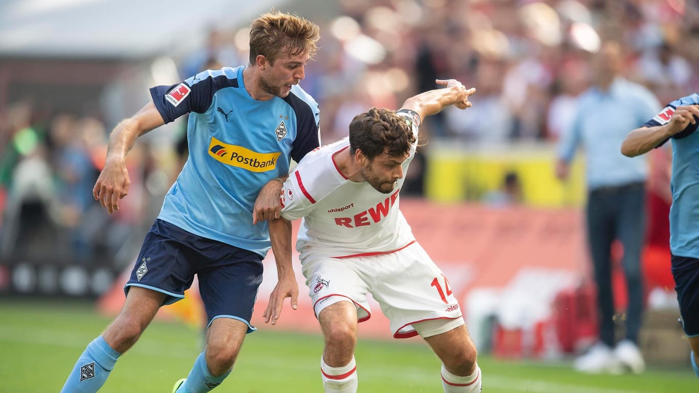 Werden ohne Zuschauerunterstützung um den Ball kämpfen: Gladbachs Christoph Kramer (l.) und Kölns Jonas Hector (r.).