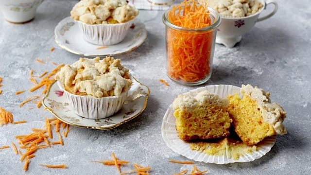 Geriebene Karotten machen den Muffins-Teig nicht nur natürlich bunt, sondern auch saftig.