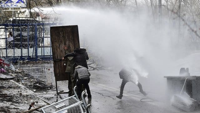 Migranten gehen an der griechisch-türkischen Grenze bei Zusammenstößen mit der griechischen Polizei in Deckung (Archiv). Migranten gehen an der griechisch-türkischen Grenze bei Zusammenstößen mit der griechischen Polizei in Deckung (Archiv).