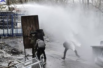 Migranten gehen an der griechisch-türkischen Grenze bei Zusammenstößen mit der griechischen Polizei in Deckung (Archiv).