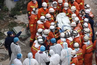 Rettungskräfte bergen einen Mann aus den Trümmern des eingestürzten Hotels.