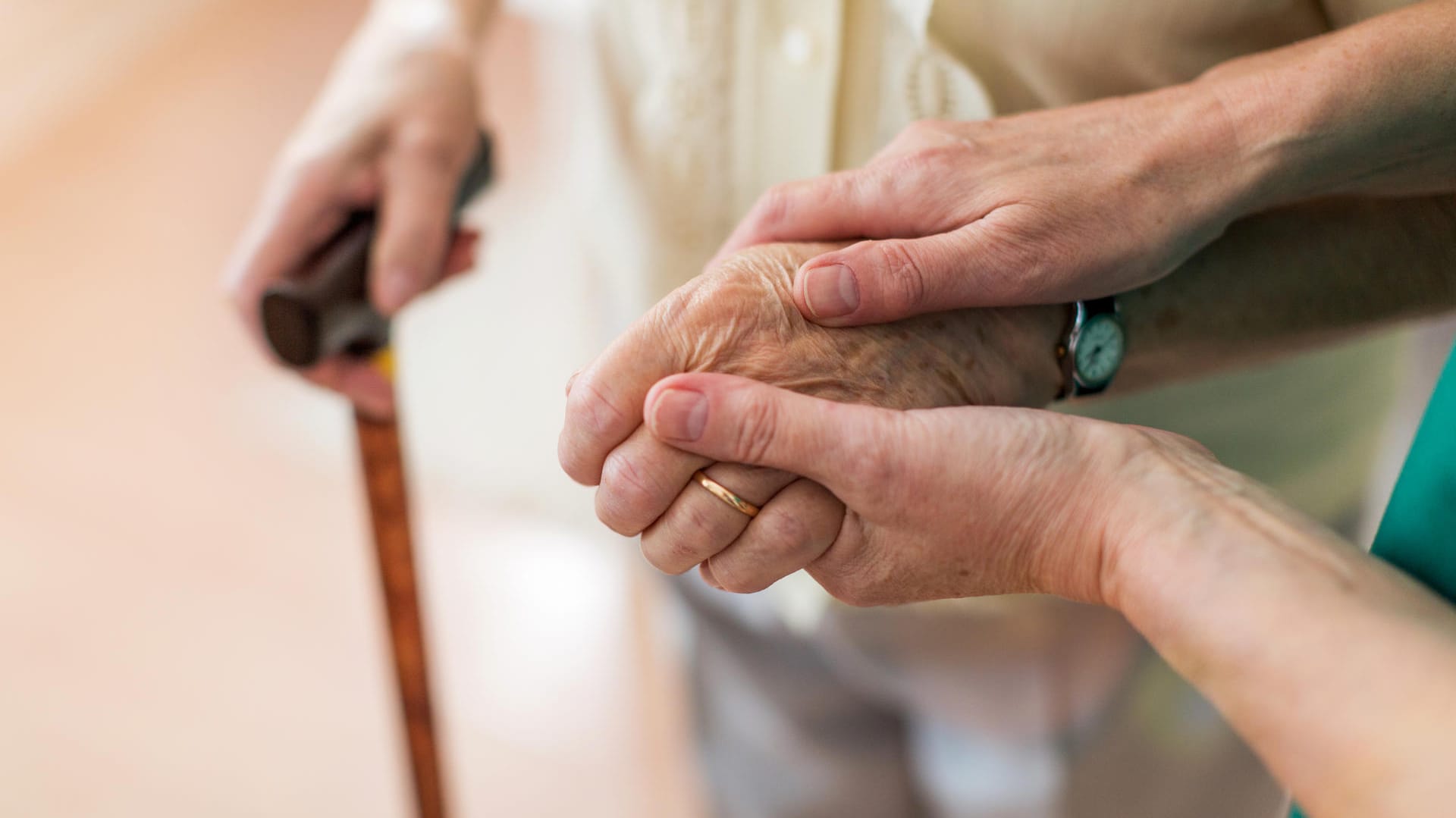 Eine Frau hält die Hand einer älteren Dame: In Demenz-WGs herrscht das Prinzip der gegenseitigen Solidarität.