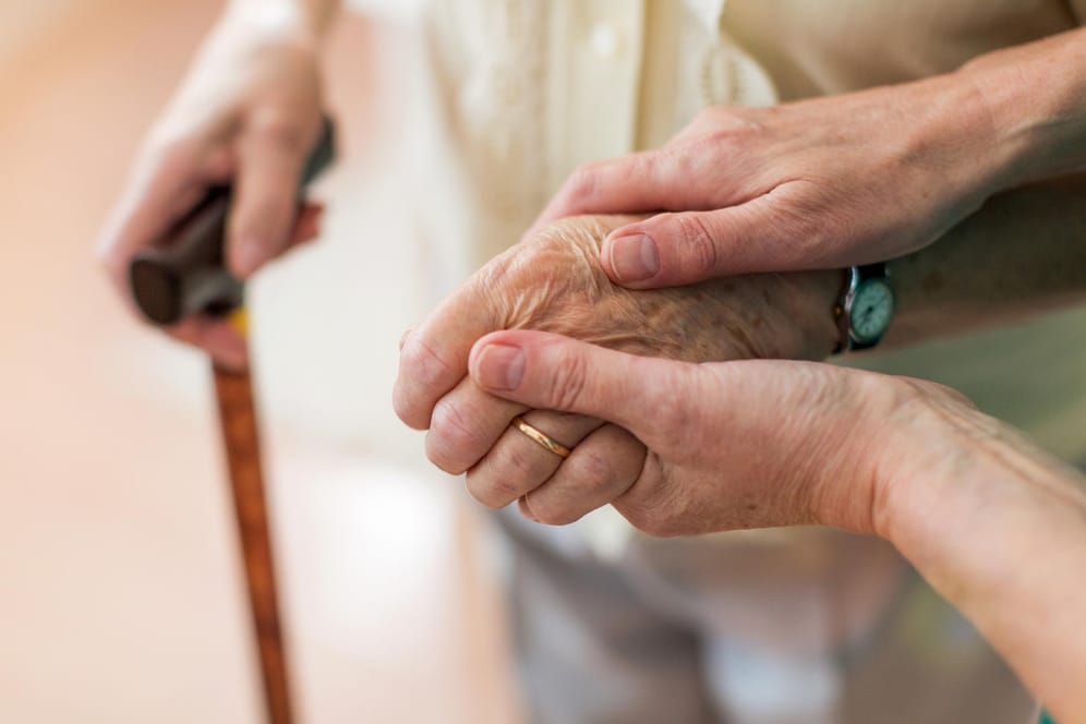 Eine Frau hält die Hand einer älteren Dame: In Demenz-WGs herrscht das Prinzip der gegenseitigen Solidarität.