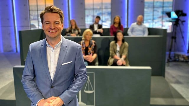 Alexander Stevens, Moderator und juristischer Experte, steht vor den sieben Juroren. Alexander Stevens, Moderator und juristischer Experte, steht vor den sieben Juroren.