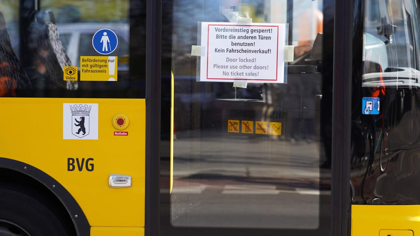 Auf der vorderen Tür eines BVG-Busses klebt ein Hinweiszettel: Aus Sorge um das Coronavirus bleibt die Tür geschlossen.