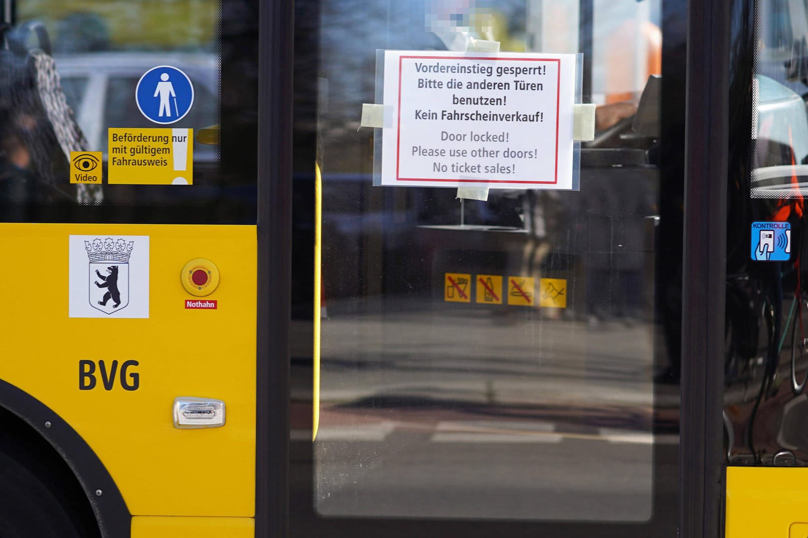 Auf der vorderen Tür eines BVG-Busses klebt ein Hinweiszettel: Aus Sorge um das Coronavirus bleibt die Tür geschlossen.