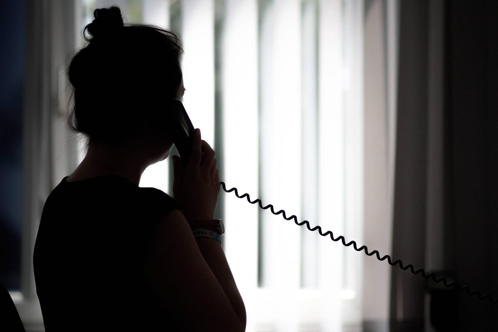 Eine Frau telefoniert (Symbolbild): In Wolfsburg warnt die Polizei vor Betrügern, die sich die Sorge um das Coronavirus zunutze machen könnten.