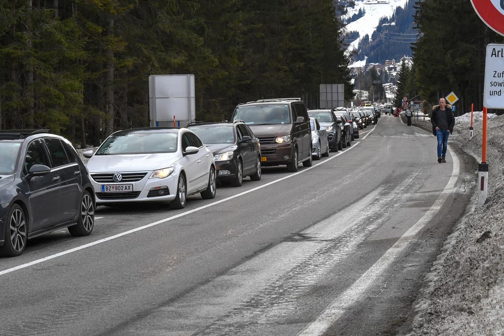 Autos stauen sich an einer Polizeikontrolle am Ortsrand von Sankt Anton am Arlberg: Ausländische Feriengäste dürfen den abgesperrten Ort noch verlassen.