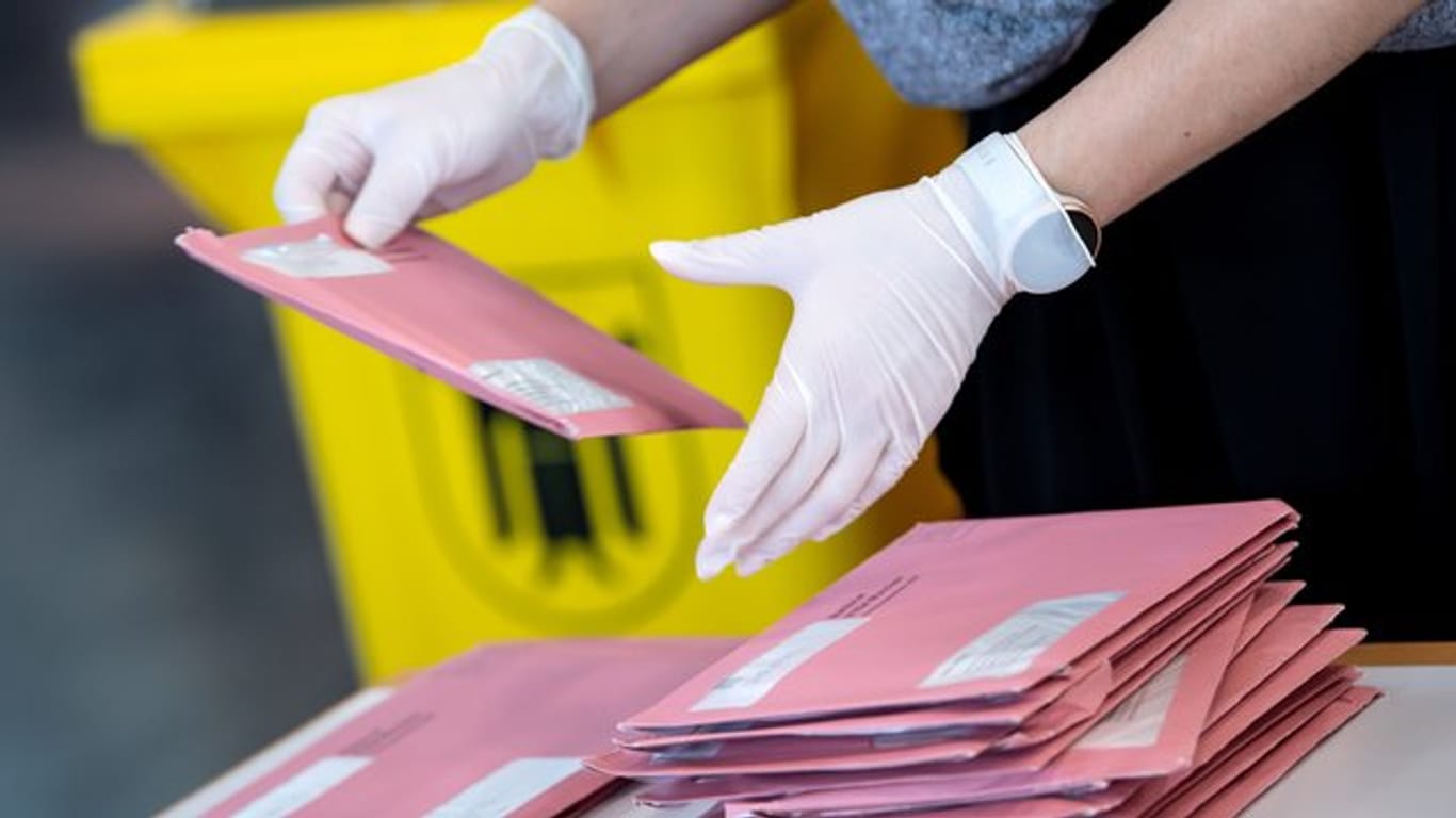 Wahlhelfer bereiten in München die Auszählung der Briefwahl vor.