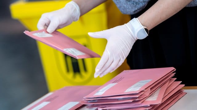 Wahlhelfer bereiten in München die Auszählung der Briefwahl vor.