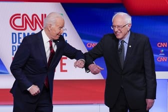 Bernie Sanders (r), und Joe Biden begrüßen sich mit ihren Ellenbogen.