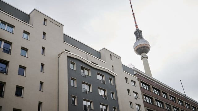 Der Fernsehturm steht hinter Häusern mit Mietwohnungen.