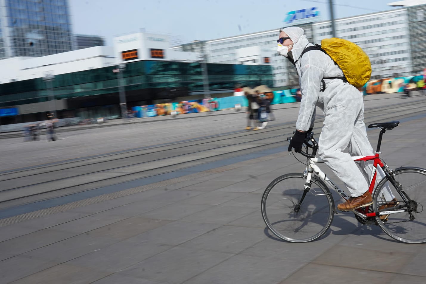 Berlin, Alexanderplatz: Ein junger Mann fährt in Schutzkleidung über den leeren Platz. Sonst wimmelt es dort von Menschen.