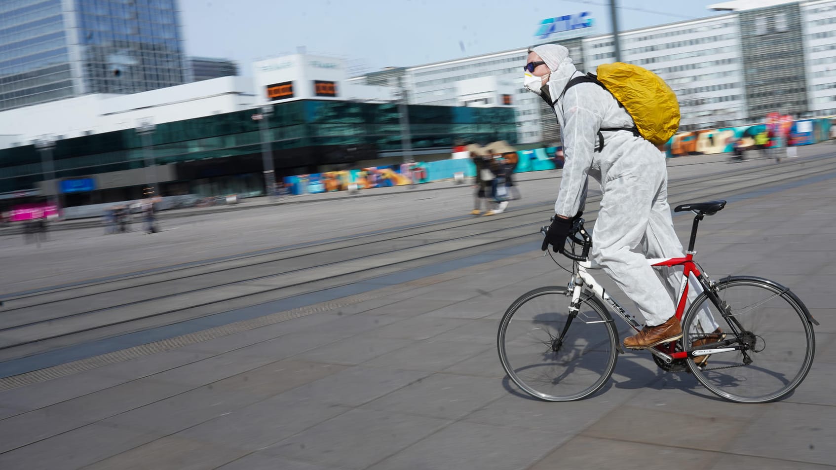 Berlin, Alexanderplatz: Ein junger Mann fährt in Schutzkleidung über den leeren Platz. Sonst wimmelt es dort von Menschen.