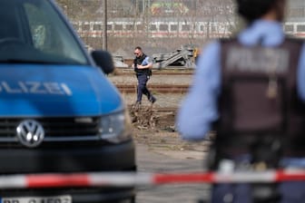 Leipzig: Polizisten stehen an dem Bahngelände, auf dem eine leblose Frau gefunden worden ist. Die Spurensuche dauert an.