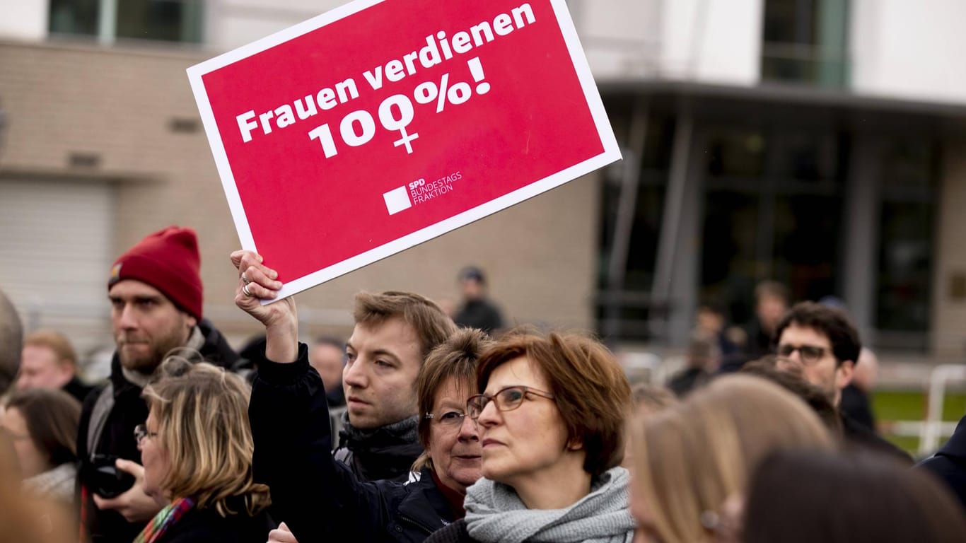 Eine Demonstrantin am Weltfrauentag: Frauen verdienen im Schnitt weniger Geld als Männer.