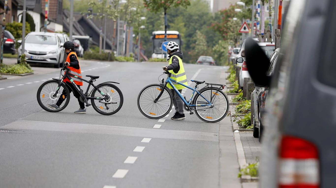 Kinder überqueren mit einem Fahrrad die Straße: In Hagen konnte ein Mann zwei Kinder vor einem Unfall retten (Symbolbild).