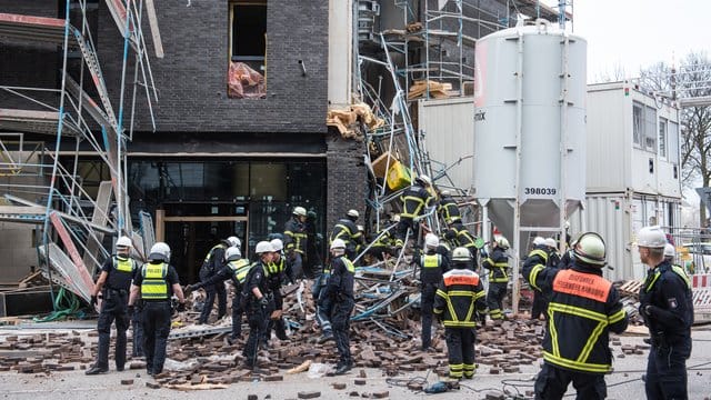 Einsatzkräfte sichern das eingestürzte Gerüst an der Baustelle.