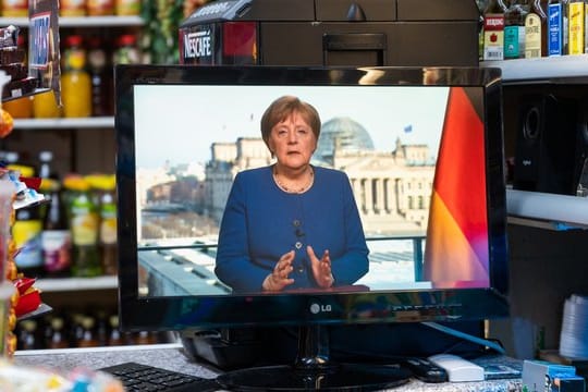 In einem Spätkauf läuft die TV-Ansprache von Bundeskanzlerin Merkel auf einem kleinen Fernseher.
