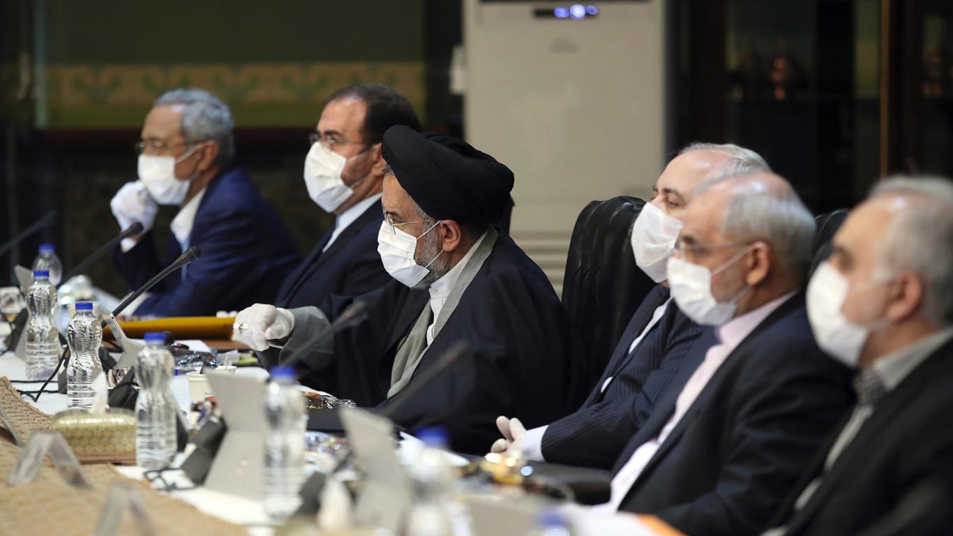 Auf diesem Foto, das auf der offiziellen Website des Büros der iranischen Präsidentschaft veröffentlicht wurde, nehmen Kabinettsmitglieder mit Mundschutz und Handschuhen an ihrer Sitzung teil.