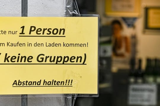 Ein Schild regelt den Einlass in ein Geschäft in Hamburg.