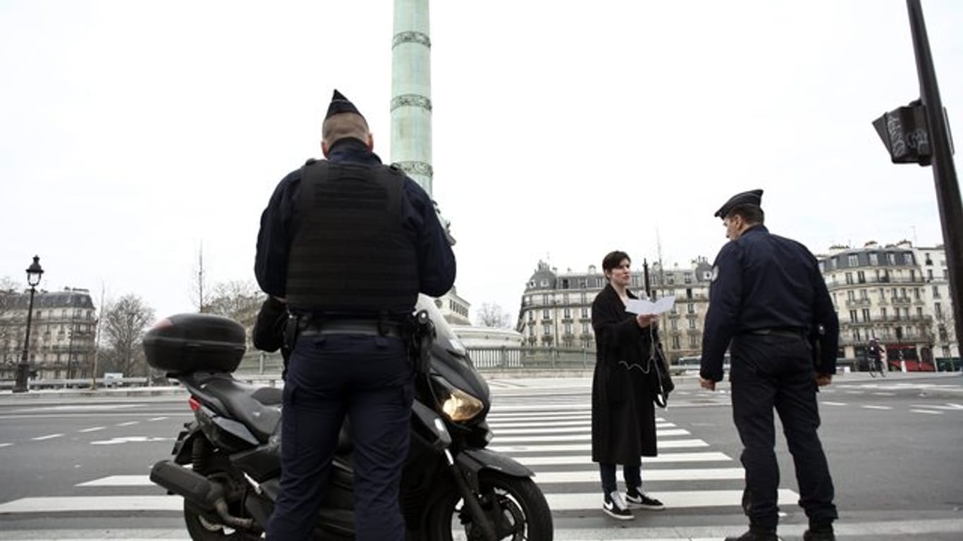 Polizeibeamte kontrollieren die Ausgangsformulare an einer Kontrollstelle in Paris.