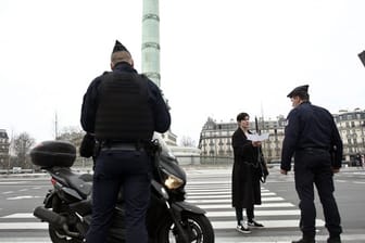 Polizeibeamte kontrollieren die Ausgangsformulare an einer Kontrollstelle in Paris.