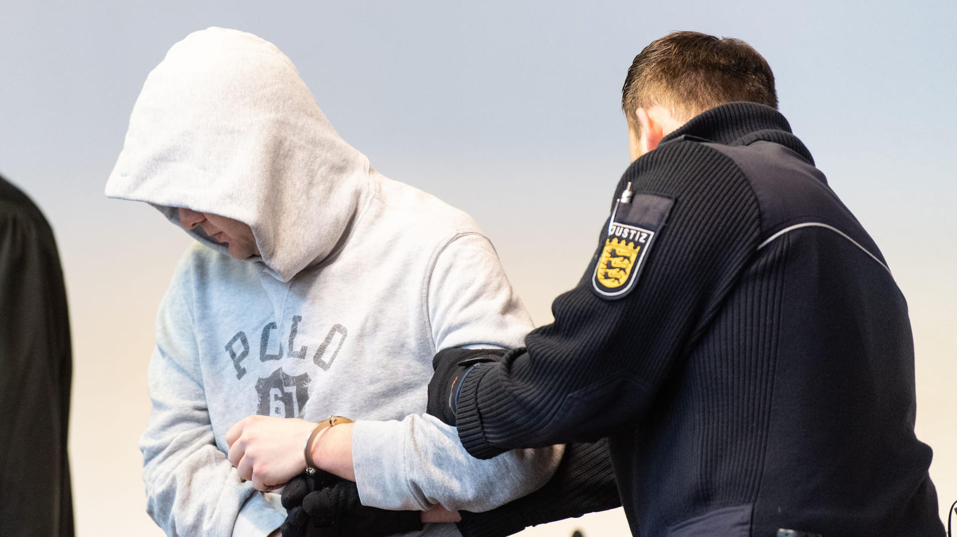 Der Verurteilte und ein Justizbeamter im Sitzungssaal während des Prozesses: Der 33-Jährige wurde nach dem Angriff in Sicherheit gebracht. Der Verurteilte und ein Justizbeamter im Sitzungssaal während des Prozesses: Der 33-Jährige wurde nach dem Angriff in Sicherheit gebracht.