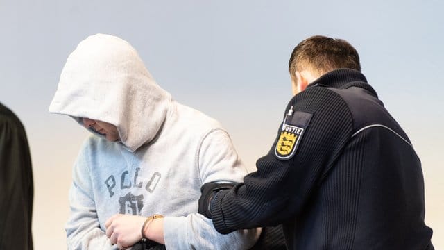 Der Angeklagte wird von einem Justizbeamte in den Sitzungssaal des Landgerichts gebracht. Der Angeklagte wird von einem Justizbeamte in den Sitzungssaal des Landgerichts gebracht.