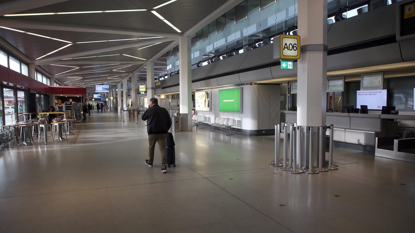 Berlin: Ein Passagier geht an leeren Abfertigungsschaltern im fast menschenleeren Terminal des Flughafens Tegel vorbei.