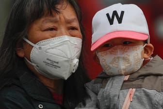 Zwei Menschen mit Atemschutzmasken in China: Das Land hat seine Quarantänebestimmungen für Einreisende noch einmal verschärft.