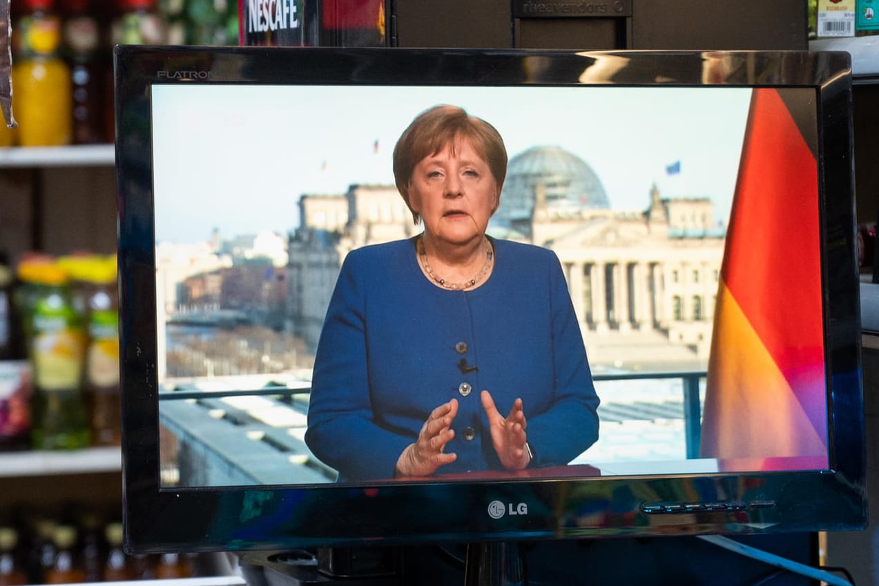 In einem Spätkauf läuft die TV-Ansprache der Bundeskanzlerin auf einem Fernseher: Um die Ausbreitung des Coronavirus zu verlangsamen, hat die Bundesregierung das öffentliche Leben erheblich eingeschränkt.
