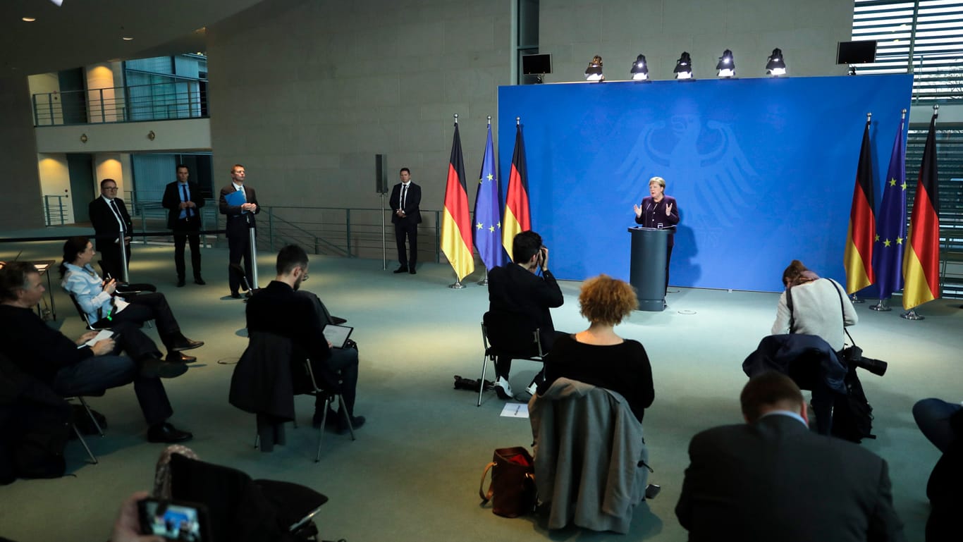 Berlin: Angela Merkel gibt im Kanzleramt ein Statement über den Coronavirus-Ausbruch, die Journalisten sitzen zu ihrem eigenen Schutz weit voneinander entfernt.