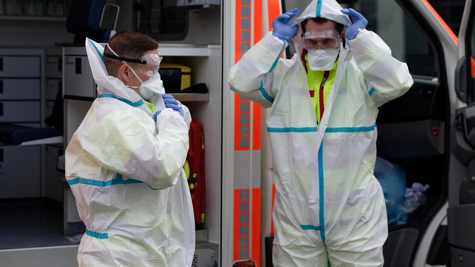 Zwei Rettungssanitäter demonstrieren Infektionschutzkleidung: Viele Menschen in Deutschland machen sich wegen des Coronavirus Sorgen Zwei Rettungssanitäter demonstrieren Infektionschutzkleidung: Viele Menschen in Deutschland machen sich wegen des Coronavirus Sorgen