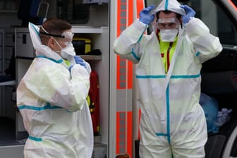 Zwei Rettungssanitäter demonstrieren Infektionschutzkleidung: Viele Menschen in Deutschland machen sich wegen des Coronavirus Sorgen