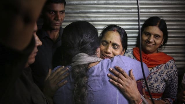 Asha Devi, die Mutter des Opfers, wird umarmt, nachdem die Vergewaltiger ihrer Tochter hingerichtet worden sind. Asha Devi, die Mutter des Opfers, wird umarmt, nachdem die Vergewaltiger ihrer Tochter hingerichtet worden sind.