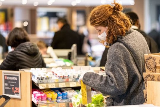 Sicher ist sicher: Mit einer Schutzmaske kauft eine Frau in einem Supermarkt ein.