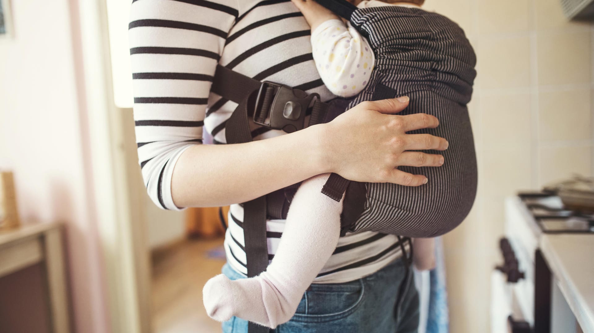 Tragehilfe: Eine Babytrage sollte dem Nachwuchs ermöglichen, in der Anhock-Spreiz-Haltung Platz zu nehmen. Die Beine sind dabei etwas angezogen und leicht nach außen gespreizt.