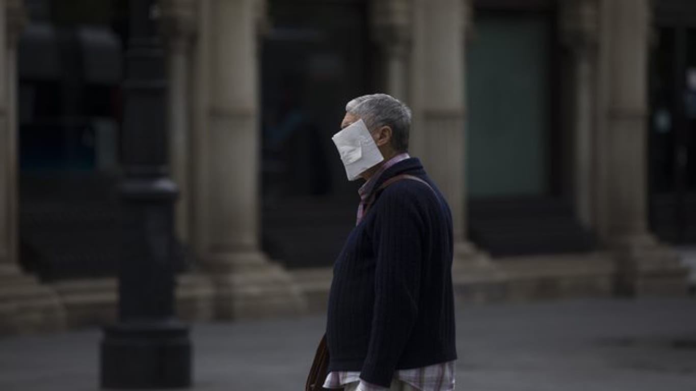 Ein Mann mit einer selbstgemachten Schutzmaske im Zentrum von Sevilla.