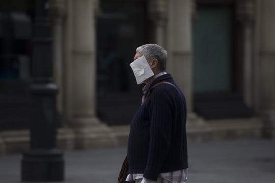 Ein Mann mit einer selbstgemachten Schutzmaske im Zentrum von Sevilla.