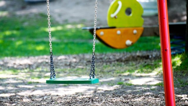 Eine leere Schaukel auf einem Spielplatz Eine leere Schaukel auf einem Spielplatz