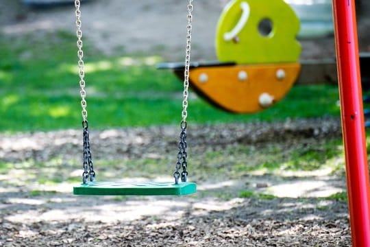 Eine leere Schaukel auf einem Spielplatz