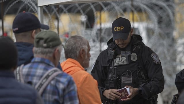 Ein Grenzbeamter kontrolliert in Tijuana am Grenzübergang zwischen Mexiko und den USA einen Pass. Ein Grenzbeamter kontrolliert in Tijuana am Grenzübergang zwischen Mexiko und den USA einen Pass.