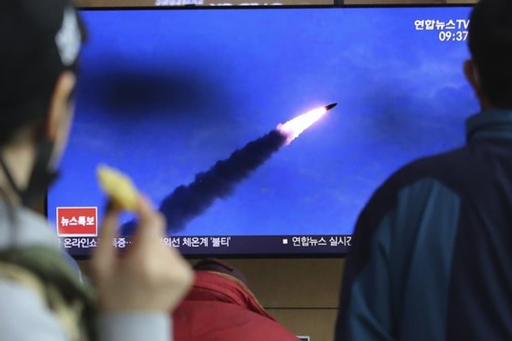 Menschen im Bahnhof von Seoul verfolgen eine Nachrichtensendung, in der über den Abschuss der Raketen berichtet wird.