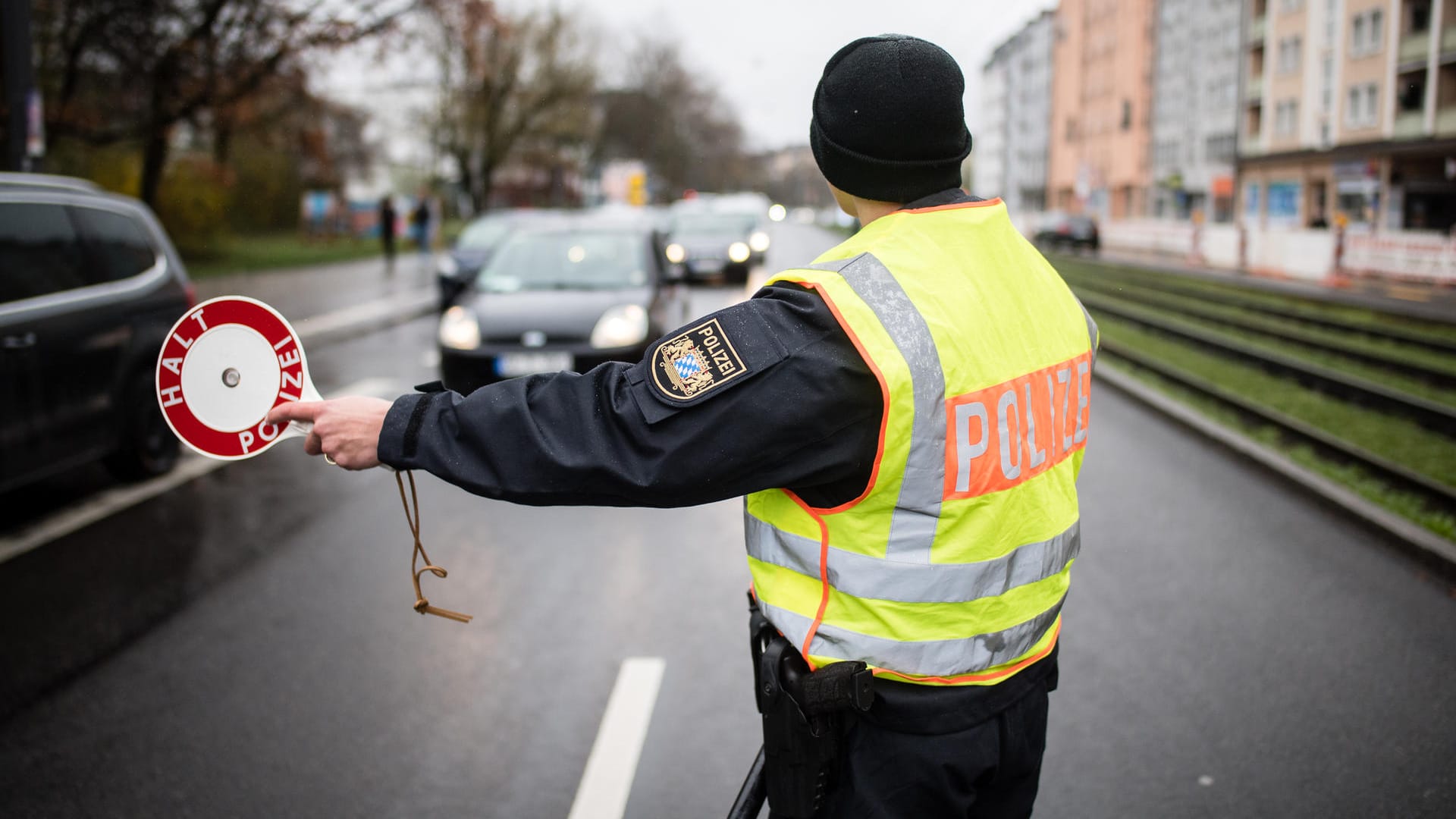 Ein Polizist stoppt an einer Kontrollstelle in München ein Fahrzeug: Bis auf Ausnahmen halten sich die Menschen bislang an die Ausgangsbeschränkungen.